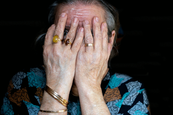 Äldre kvinna med händerna för ansiktet, kopplat till måndagsångest, höga kortisolnivåer, stress och hjärtproblem.