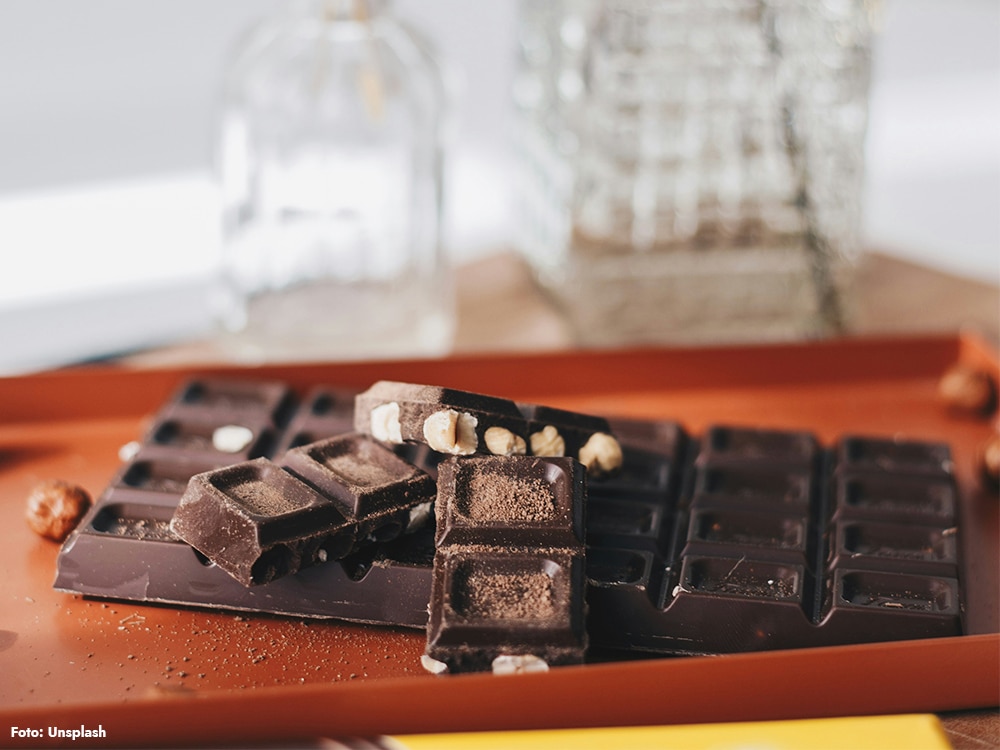 Bitad mörk choklad med nötter på orange bricka (kakao med teobromin).