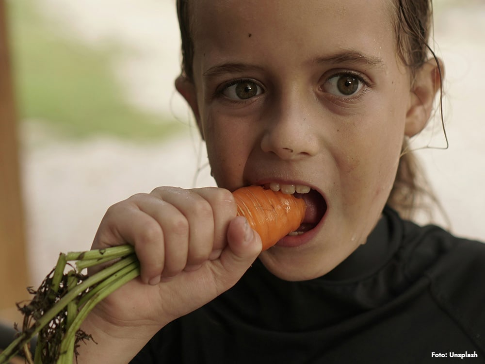 Barn som äter grönsaker – vegankost för barn kräver planering för att minska risk för kalciumbrist och B12-brist.