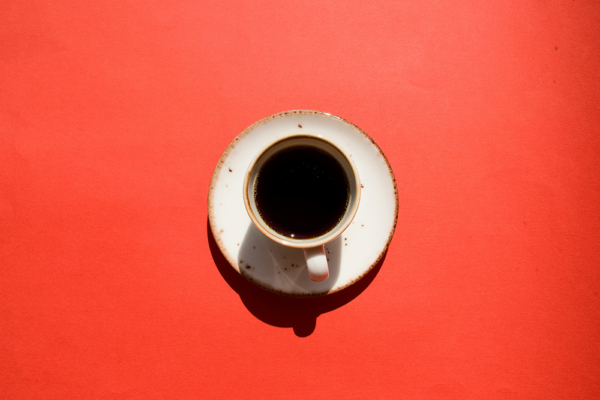 Kopp kaffe på röd bakgrund, illustrativ bild om kaffe och demens.