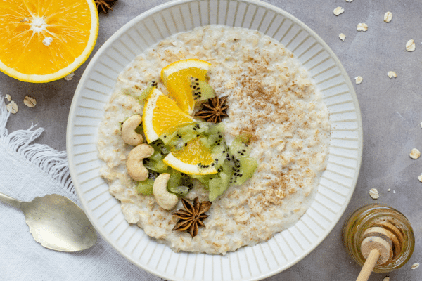 LDL-kolesterol: havregrynsgröt med apelsin, kiwi, cashewnötter och kanel på tallrik.