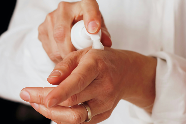 Bodylotion bäst i test – person smörjer in händerna med återfuktande lotion mot torr hud