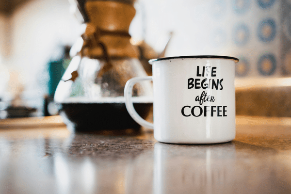 Kaffebryggare bäst i test – kaffekopp bredvid en kanna med nybryggt kaffe på köksbänken