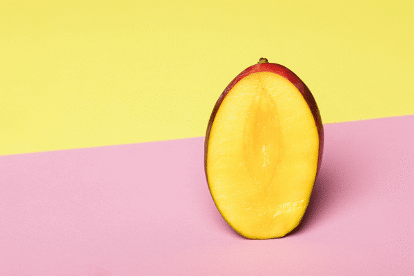Halverad mango på färgad bakgrund – mango och blodsocker vid prediabetes