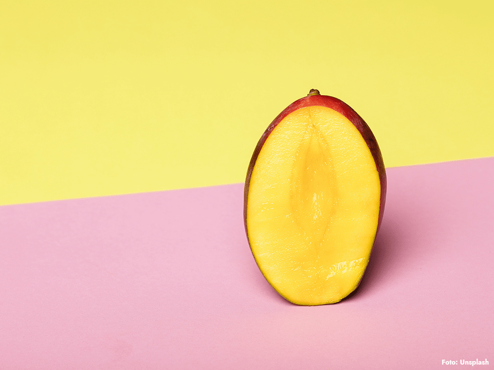 Halverad mango på färgad bakgrund – mango och blodsocker vid prediabetes