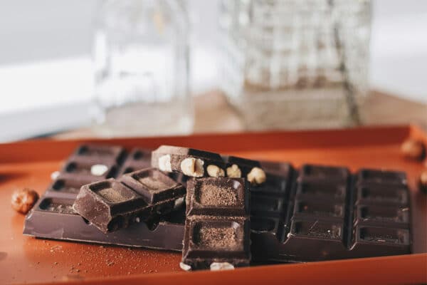 Bitad mörk choklad med nötter på orange bricka (kakao med teobromin).