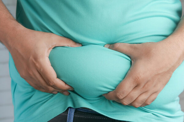 Person håller om magen – illustration av viktuppgång efter Ozempic och utmaningen att behålla vikt efter Ozempic.